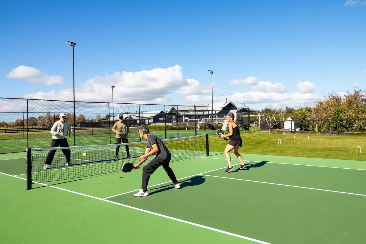 Group playing pickleball on the court at Lawn Road Retreat, Hawke's Bay