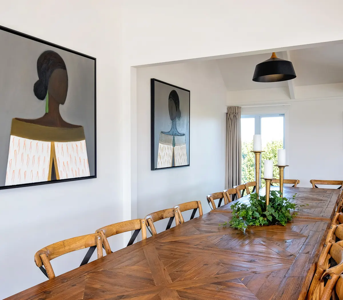 Large group dining table with original artwork at Lawn Road Retreat, Hawke's Bay